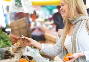 Happy blond woman buying food at market.